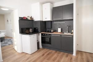 a kitchen with black and white appliances in a room at Deluxe Urban Stay in Linz