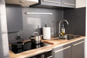 a kitchen with a sink and a counter top at Deluxe Urban Stay in Linz +7 photos