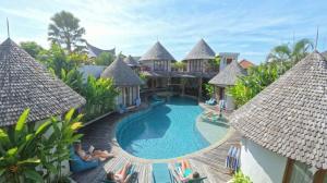 a resort with a swimming pool and people laying around it at Villa Manureva in Canggu