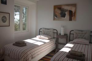 a bedroom with two beds and a picture on the wall at Casa 7 in Sintra