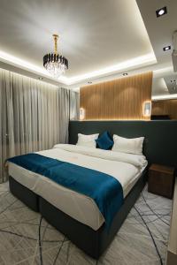 a bedroom with a large bed with a blue blanket at LakeSide Hotel by EDEN Group in Tashkent +71 photos