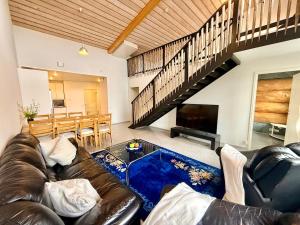 a living room with a leather couch and a table at Villa Cuisine in Joensuu