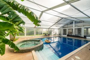 an indoor swimming pool with a glass ceiling at Villa Florence in Tirana