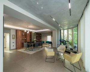 a living room with chairs and a dining room at Villa Florence in Tirana