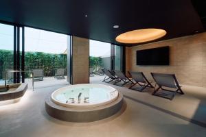a living room with a hot tub and chairs at FAV LUX Nagasaki in Nagasaki