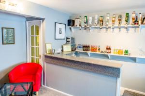 a bar with a red chair in a room at The Avenue in Shanklin