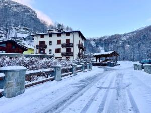 a snow covered road in front of a building at Cervinia House - Alpine Apartments & Chalet in Valtournenche