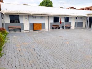 a white building with benches in front of it at Villa Hospedagem in Palmas