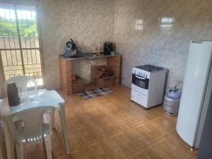 a kitchen with a stove and a white refrigerator at Casa Correntina BA 3 quartos in Correntina