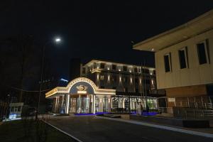 a lit up building at night with a street light at LakeSide Hotel by EDEN Group in Tashkent