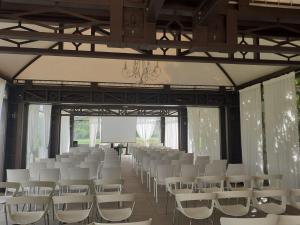 a conference room with white chairs and a screen at Agriturismo Villa Anconetta in Loreo