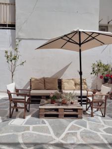 a patio with a couch and an umbrella at Feidiou 1 vol II in Egina