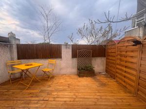 a patio with a table and chairs and a fence at Eaunes au Soleil in Eaunes