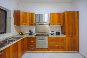 a kitchen with wooden cabinets and a stove top oven at Spacious 3BR Retreat Overlooking Marina in Msida