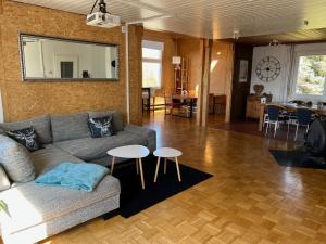 a living room with a couch and two tables at Schwarzwald Lodge OG - Perfekt für Familien und Gruppen in Calw