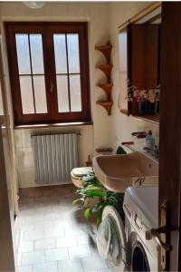 a bathroom with a sink and a washing machine at Respiro di montagna by Lago Maggiore Rentals in Vigino