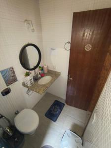 a bathroom with a toilet and a sink and a mirror at Mandalas Guest House in Cabo Frio +73 photos