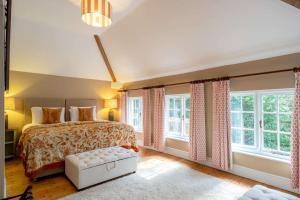 a bedroom with a bed and large windows at The Coach House in Barlestone