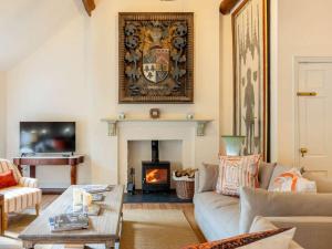 a living room with a couch and a fireplace at The Coach House in Barlestone