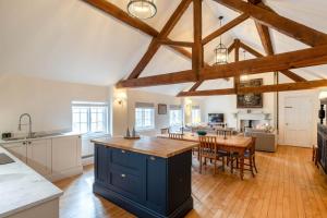 a kitchen and living room with a table and chairs at The Coach House in Barlestone