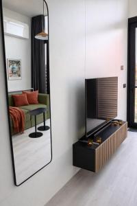 a mirror in a room with a couch and a television at EMSLAND-CAMP in Haar +42 photos