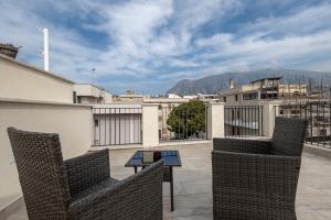 a patio with two chairs and a table on a roof at Terrasini Center Apartments By Dimora Hub in Terrasini