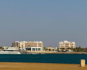a boat in a body of water with buildings in the background at Corp Yanbu Hotel - B2 in Yanbu +18 photos
