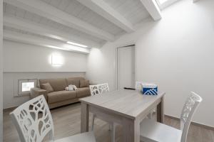 a living room with a table and chairs and a couch at Terrasini Center Apartments By Dimora Hub in Terrasini