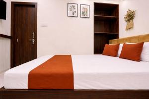 a bedroom with a large bed with orange pillows at Anushka Stays Varanasi in Varanasi