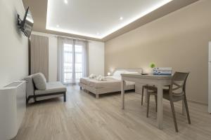 a living room with a bed and a table and chair at Terrasini Center Apartments By Dimora Hub in Terrasini