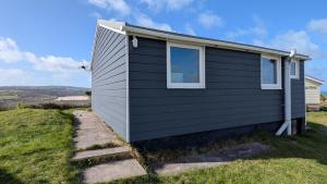 a black house with a window on the side of it at E41 Silver Mist, Riviere Towans in Hayle