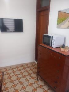 a microwave on top of a dresser in a room at Casa Maria Naxos in Giardini Naxos