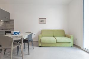 a living room with a green couch and a table at Marusu Apartments By Dimora Hub in Terrasini