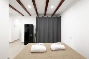 two towels on a bed in a room with a black curtain at Marusu Apartments By Dimora Hub in Terrasini