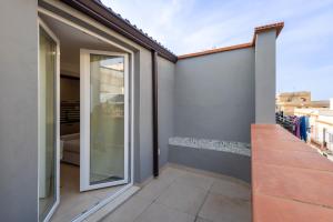 a balcony of a house with a sliding glass door at Marusu Apartments By Dimora Hub in Terrasini