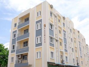 a large white building with a sign on it at Starlight Hotels DLF Trade Center Miot chennai in Chennai