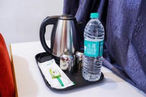 a tea kettle and a bottle of water on a table at Starlight Hotels DLF Trade Center Miot chennai in Chennai