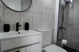 a bathroom with a sink and a toilet and a mirror at AL Adega do Calcetas in Cais do Mourato