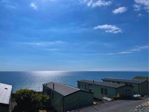 a view of the ocean with buildings and houses at Hendre Coed Isaf Caravan Park in Barmouth