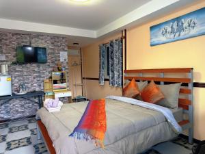 a bedroom with a bed and a tv on a wall at สมหวัง โฮมสเตย์ in Ban Khuan Suan