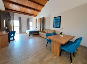 a living room with a dining room table and blue chairs at Antica Jesolo - M Factory in Jesolo +63 photos
