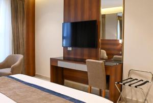 a hotel room with a desk with a television on it at Corp Yanbu Hotel - B2 in Yanbu