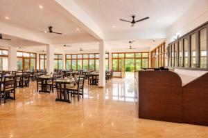 a dining room with tables and chairs and windows at Hill Crest Resort - Coorg in Madikeri
