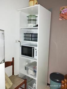 a white book shelf with a microwave in it at Appartement 974 in Le Tampon