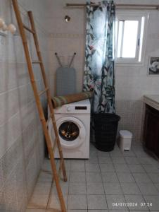 a washing machine in a bathroom with a shower at Appartement 974 in Le Tampon