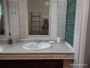 a person taking a picture of a bathroom sink at Appartement 974 in Le Tampon +21 photos
