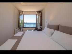 a bedroom with a large white bed and a large window at Mar de Lux in Petrovac na Moru