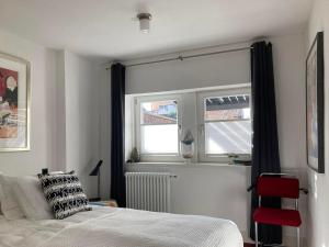 a bedroom with a bed and two windows at Bed & Breakfast Bep - Klein aber fein in Naumburg