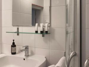 a white bathroom with a sink and a mirror at Bed & Breakfast Bep - Klein aber fein in Naumburg +10 photos
