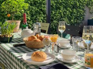 a table with a basket of bread and glasses of wine at Bed & Breakfast Bep - Klein aber fein in Naumburg